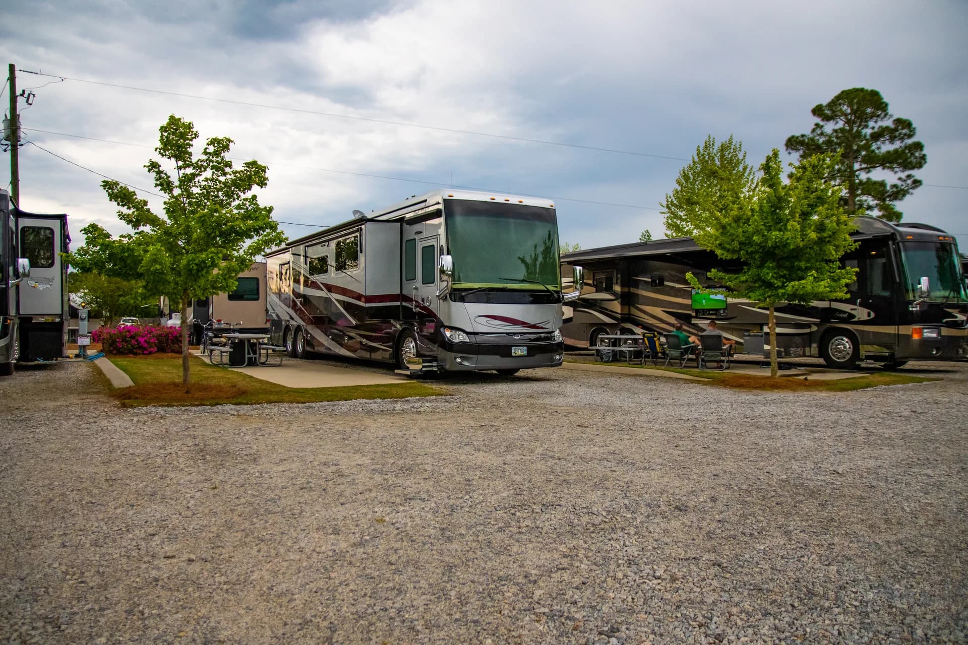 Guests relaxing under awnings beside their coaches in the late afternoon
