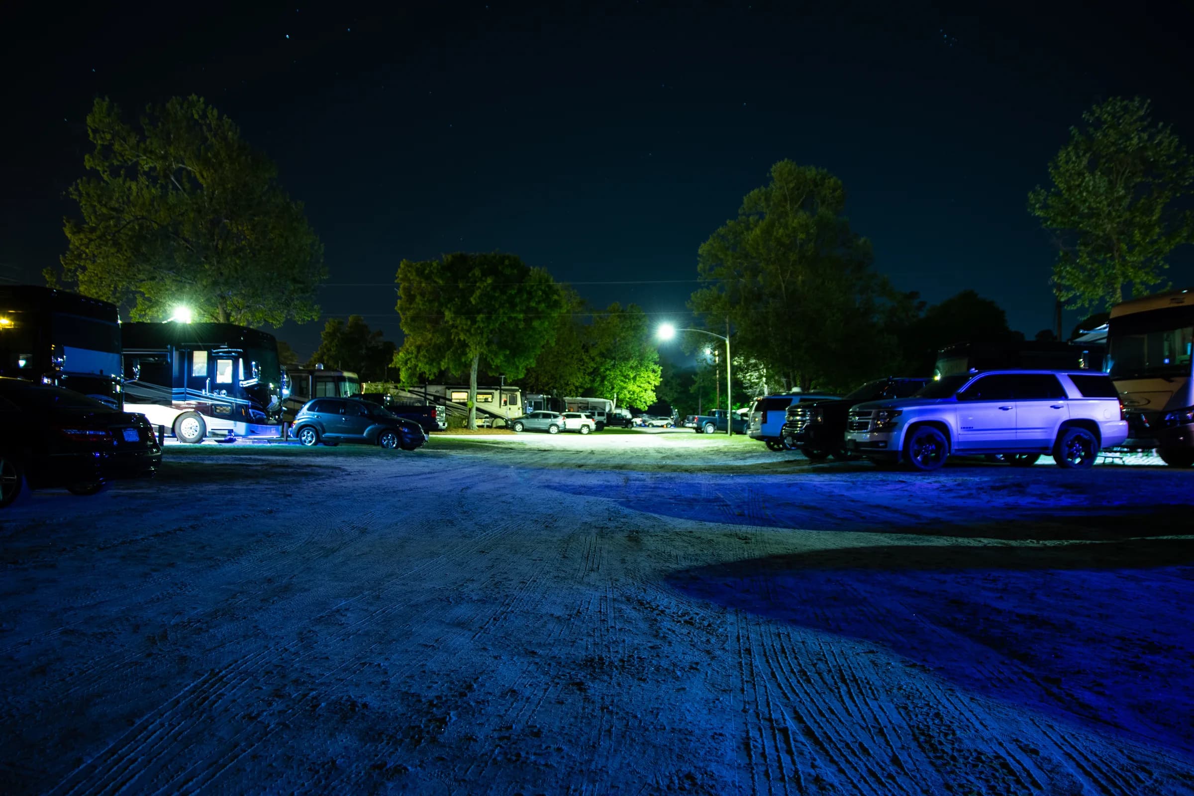 A quiet lane at Heritage RV Park at night, lit by streetlights